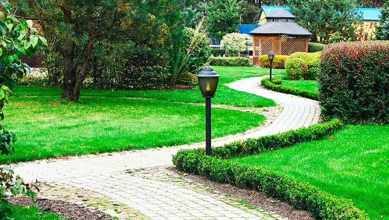 Gartenweg mit Wiesen, Bäumen und Beleuchtung